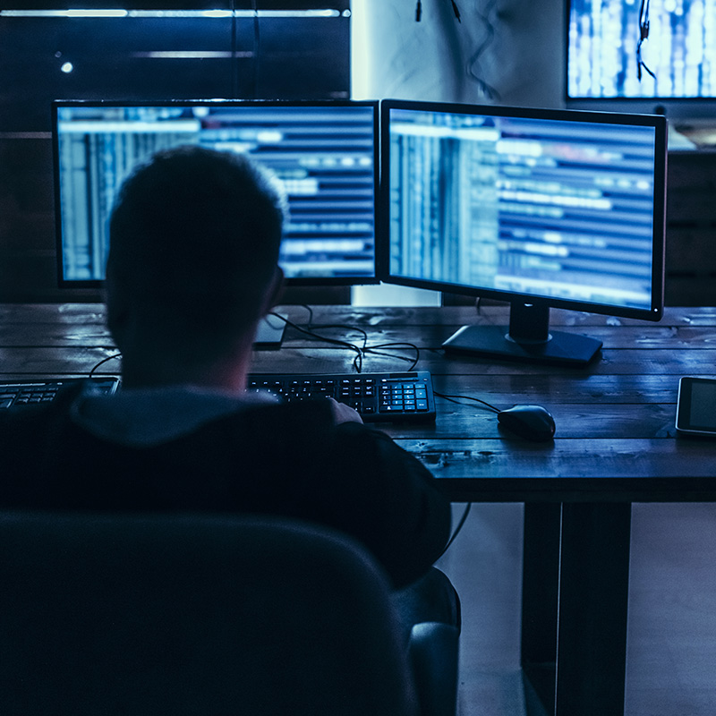 Man Sitting in front of Multiple Monitor Setup
