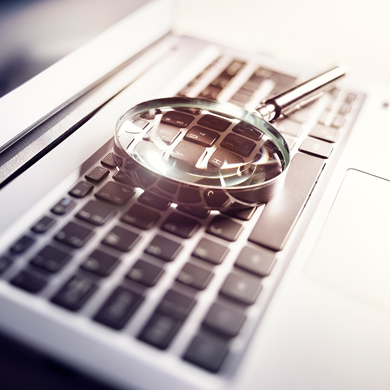 Magnifying glass on laptop keyboard